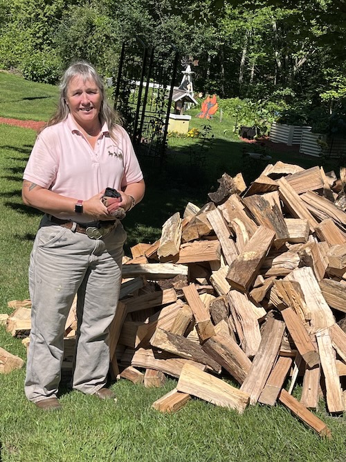 woman standing next to wood pile